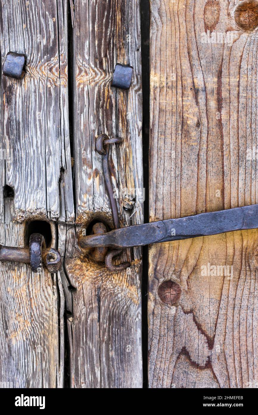 Vieille maison en rondins. Portes, portails. Poignées de porte, boulons, charnières, crochets en métal forgé et rouille. Arbre en bois, structure en bois vieilli. Banque D'Images