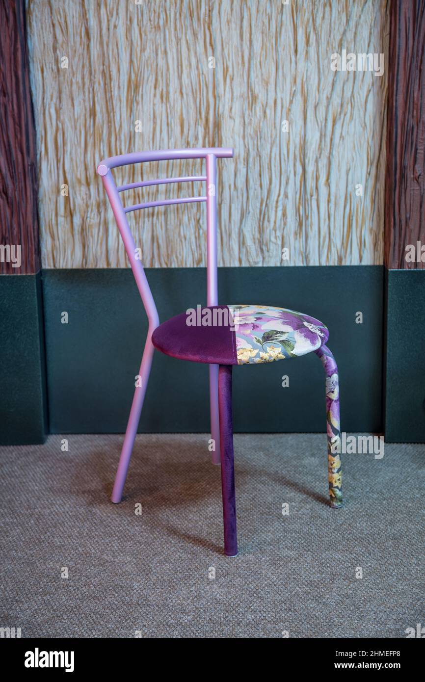 Chaise à motif floral mauve et lilas confortable sur fond de mur décoratif Banque D'Images