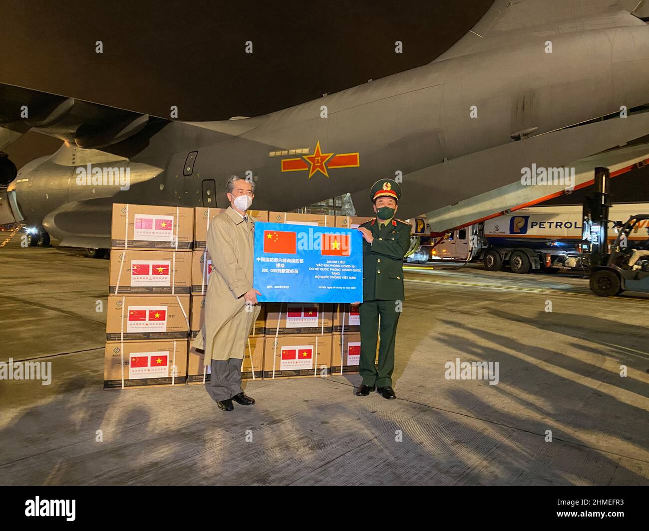 (220209) -- HANOÏ, le 9 février 2022 (Xinhua) -- l'ambassadeur chinois au Vietnam Xiong Bo (L) et Hoang Xuan Chien, ministre adjoint de la Défense nationale du Vietnam, assistent à une cérémonie de remise des vaccins COVID-19 donnés par la Chine à l'aéroport international de Noi Bai à Hanoi, au Vietnam, le 8 février 2022. Le ministère vietnamien de la Défense nationale a reçu le deuxième lot de vaccin Sinopharm COVID-19 présenté par l'Armée populaire de libération de Chine (APL).Un avion de transport de l'APL transportant les doses de vaccin est arrivé tard mardi à l'aéroport international de Noi Bai dans la capitale vietnamienne Hanoi. (Ambassade de Chine Banque D'Images