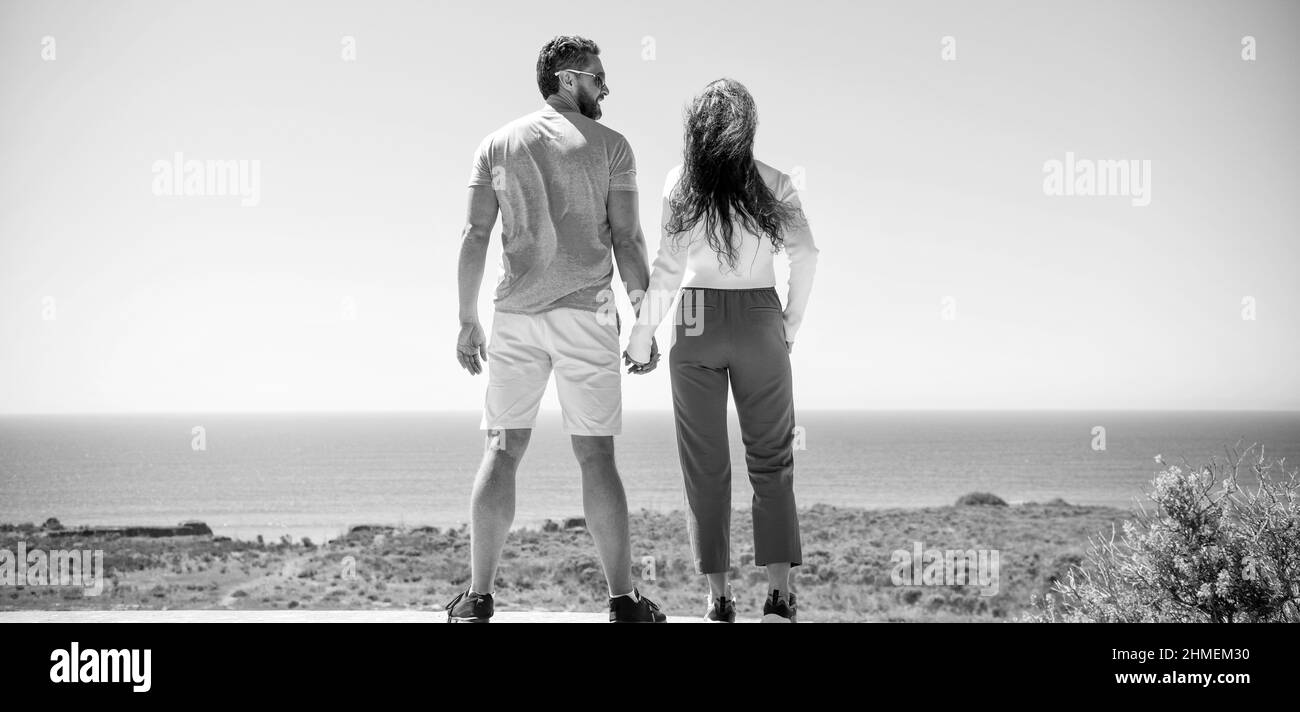 jeune famille qui cherche loin. vacances de voyage. homme et femme heureux tenant les mains. Banque D'Images