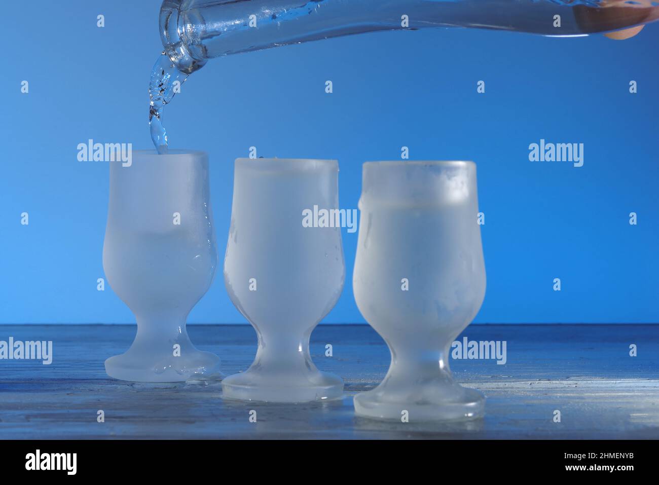 Verre de vodka sur table en bois bleu, mise au point sélective Banque D'Images