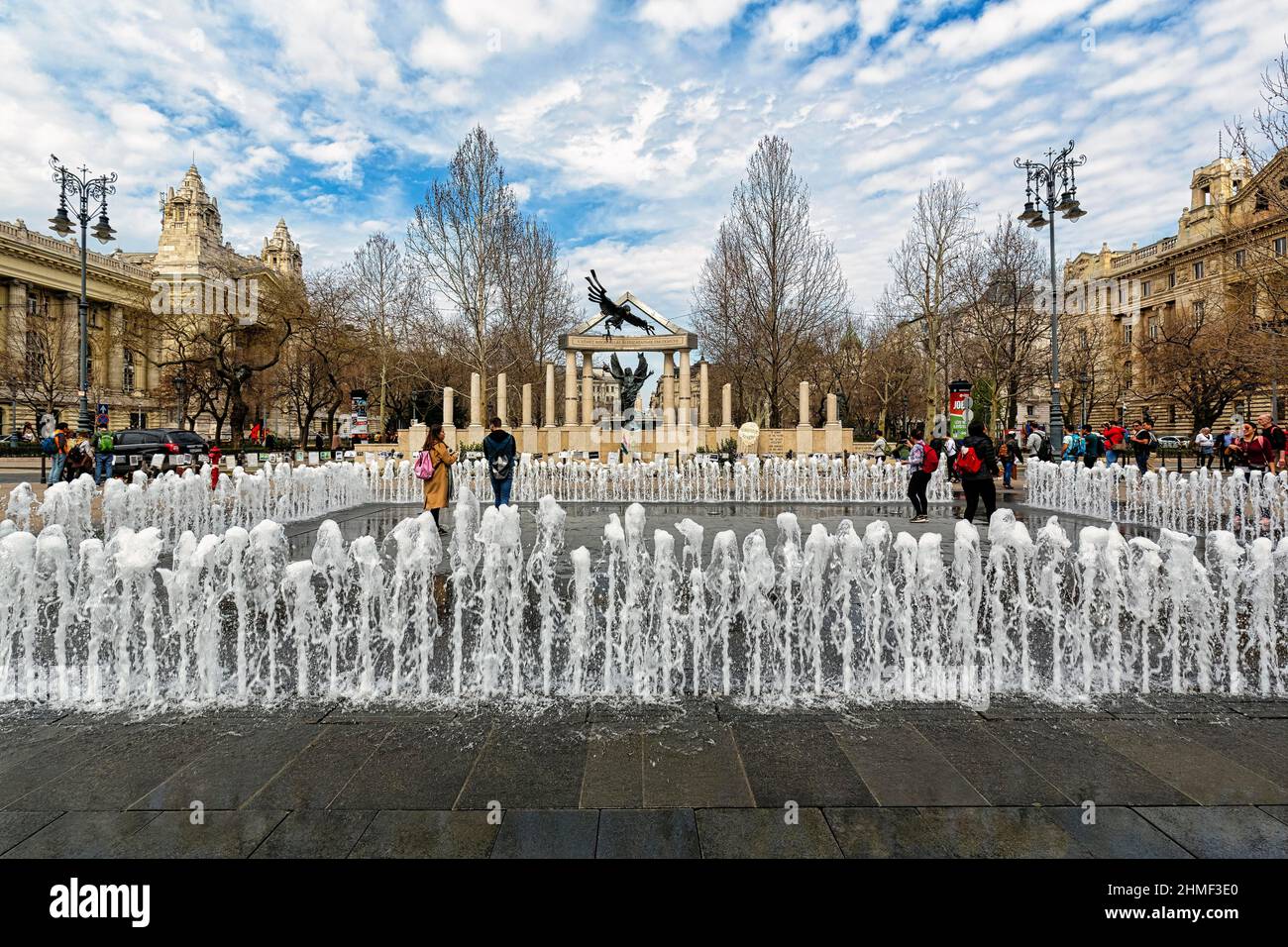 Visiteurs à la fontaine devant le monument controversé des victimes de l'occupation allemande, place de la liberté, Szabadag ter, district V. Banque D'Images