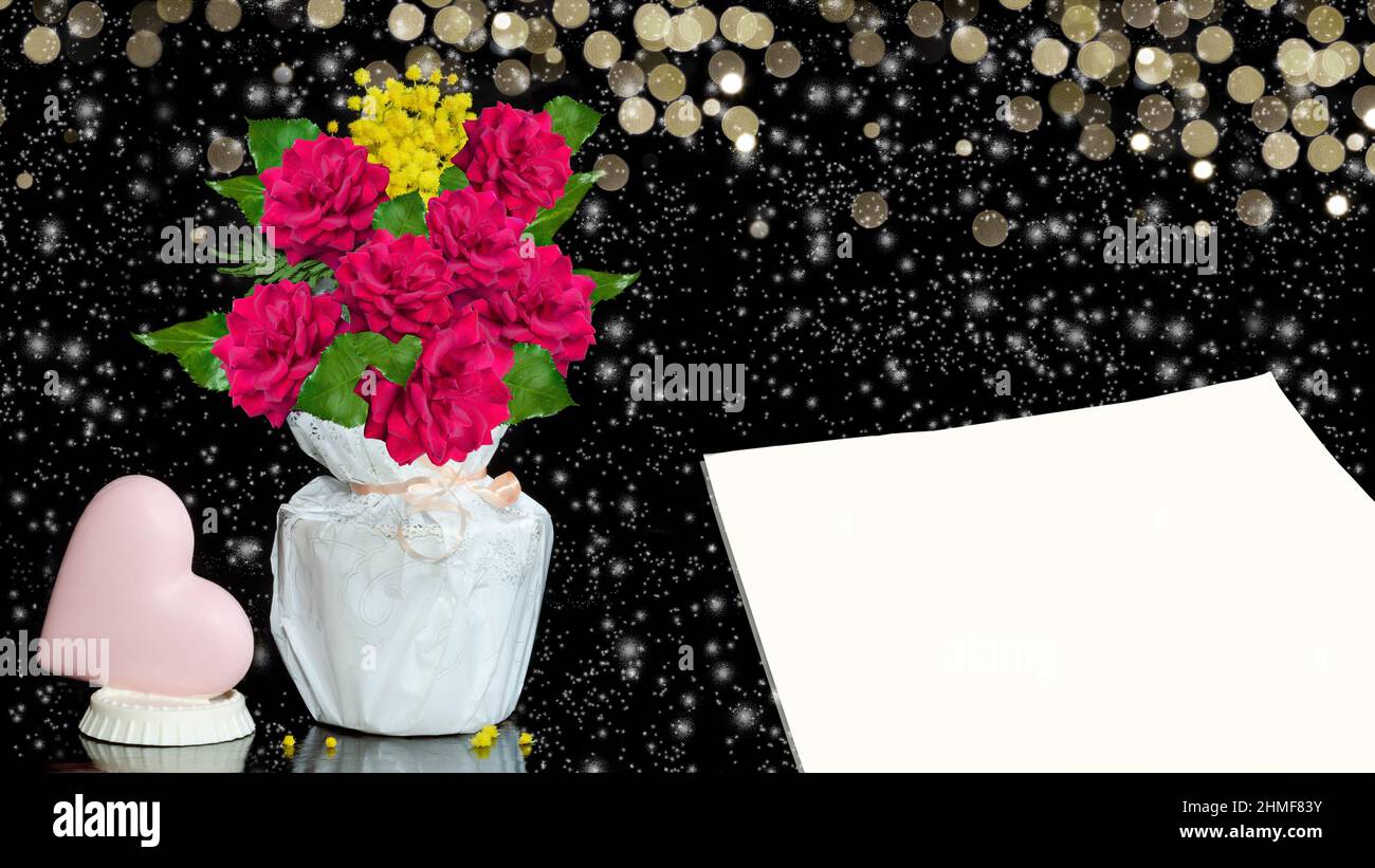 Un coeur en chocolat, un bouquet de roses dans une boîte cadeau et une feuille de papier vierge pour le texte. Fond noir avec neige et bokeh Banque D'Images