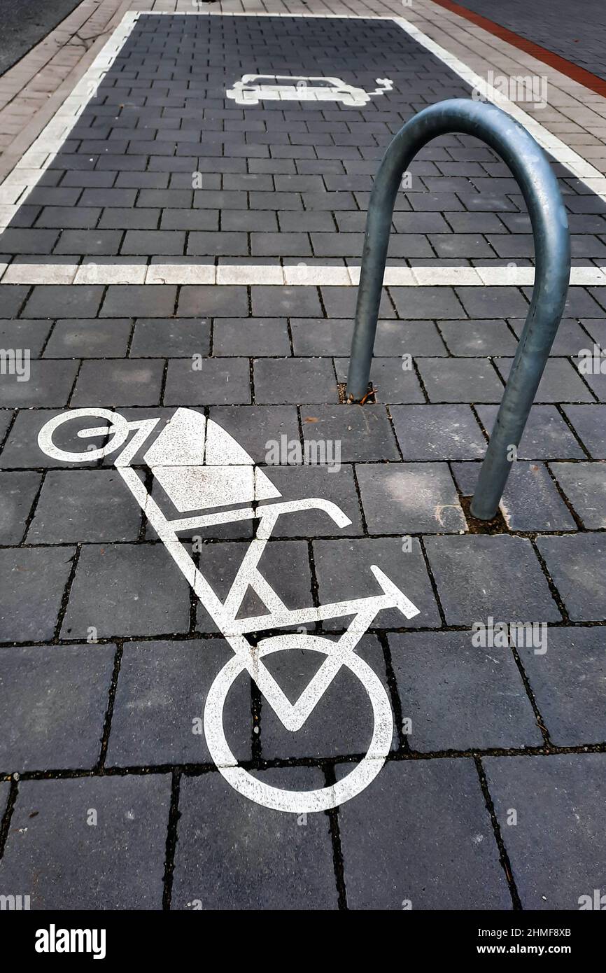 Parking pour vélos de chargement. Un symbole peint sur le trottoir montre une moto-cargo à côté d'un support de montage. Hanovre, Allemagne, 5 février 2022 --- Parkplatz für Lastenräder. Ein auf den Bürgersteig gemaltes Symbol zeigt ein Lastenfahrrad neben einem Befestigungsbügel. Hanovre, 5.2.2022 Banque D'Images