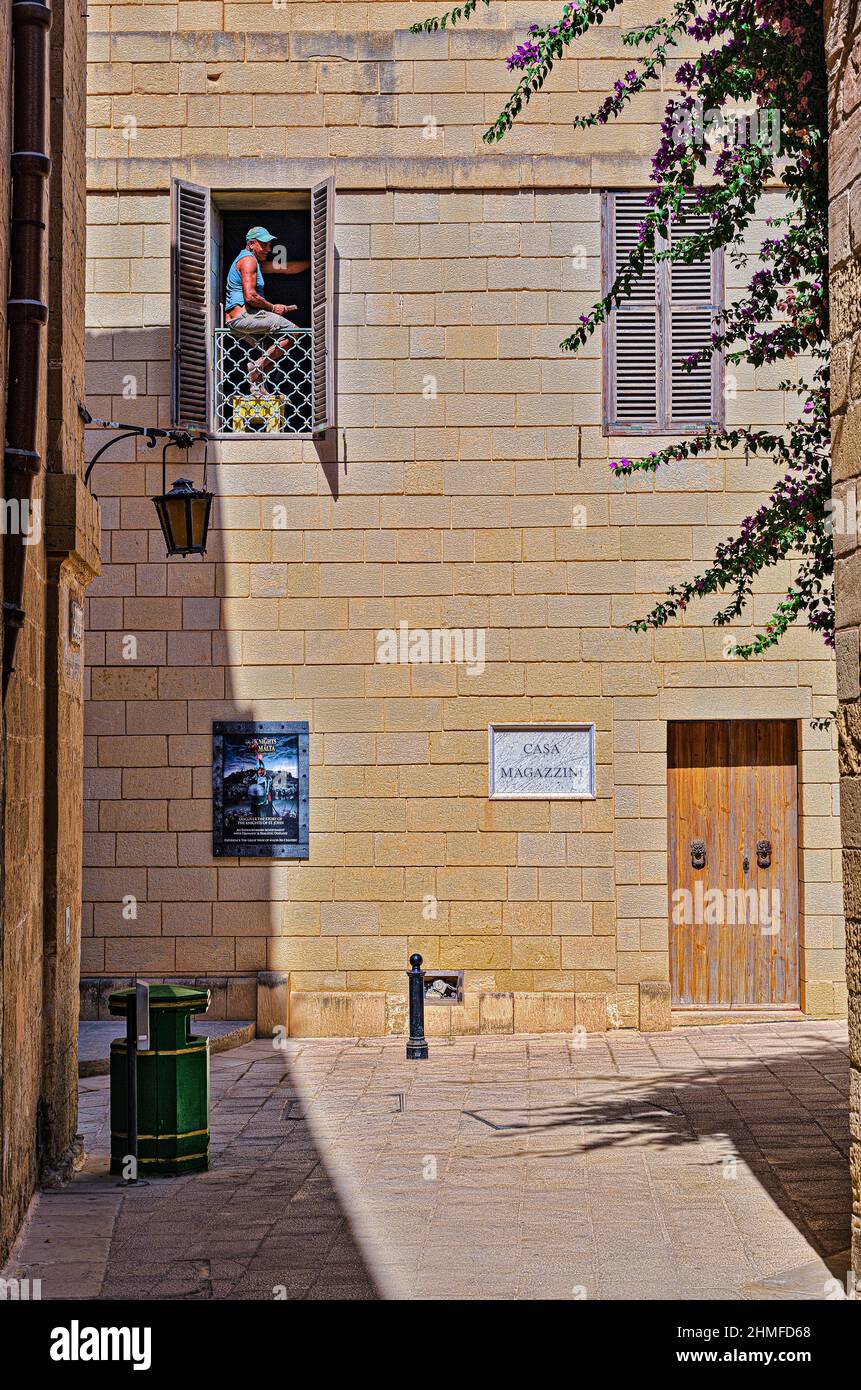 Un homme effectue des travaux de restauration sur un bâtiment médiéval à Mdina Banque D'Images