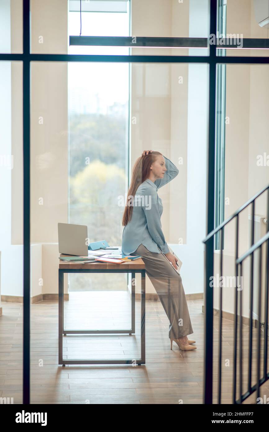 Une femme qui pense s'est penchée sur un bureau Banque D'Images