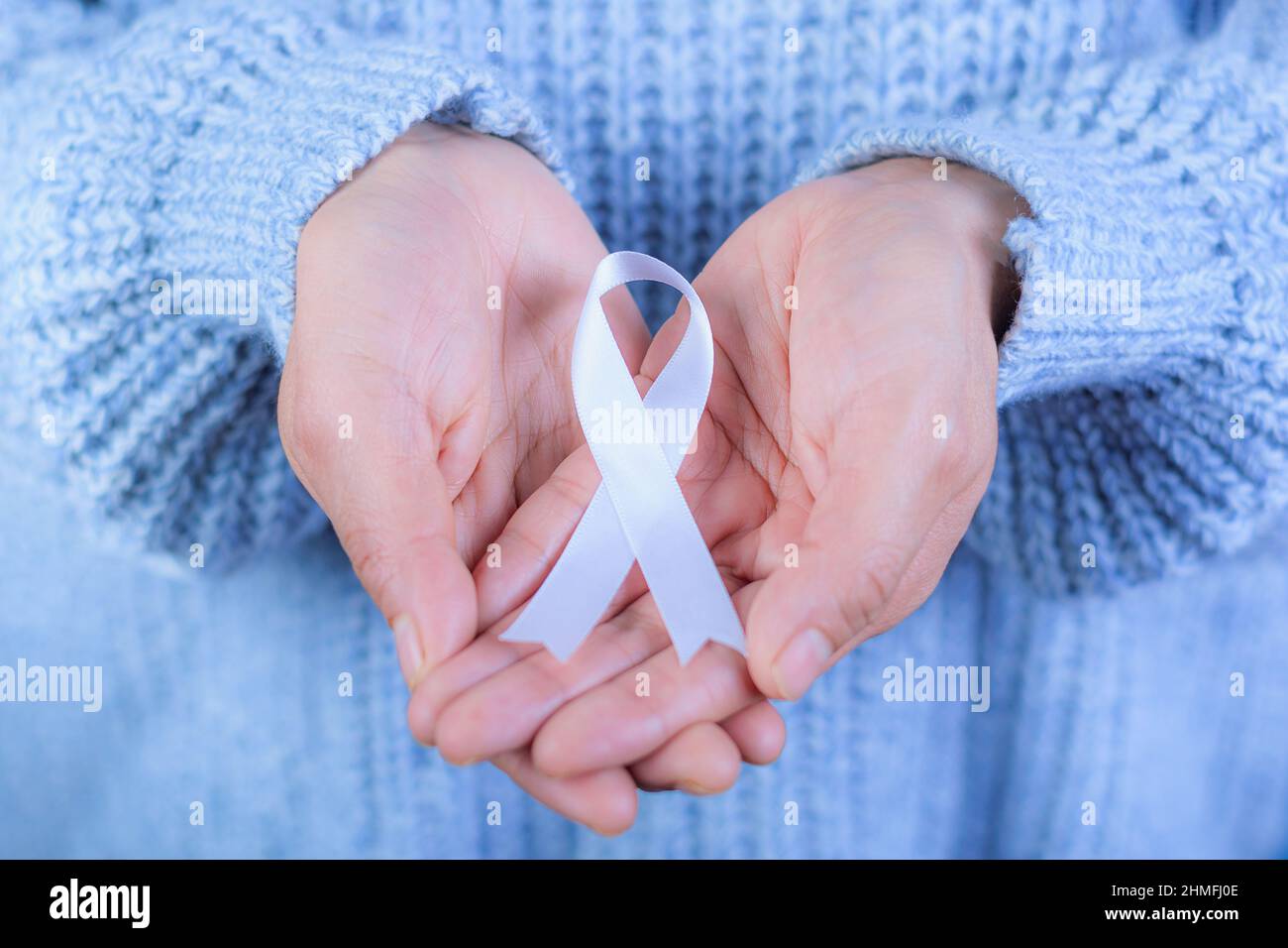 Femme avec ruban blanc en main pour le mois de novembre : mois de sensibilisation au cancer du poumon, démocratie et journée internationale de la paix. Concept de santé, Spac Banque D'Images