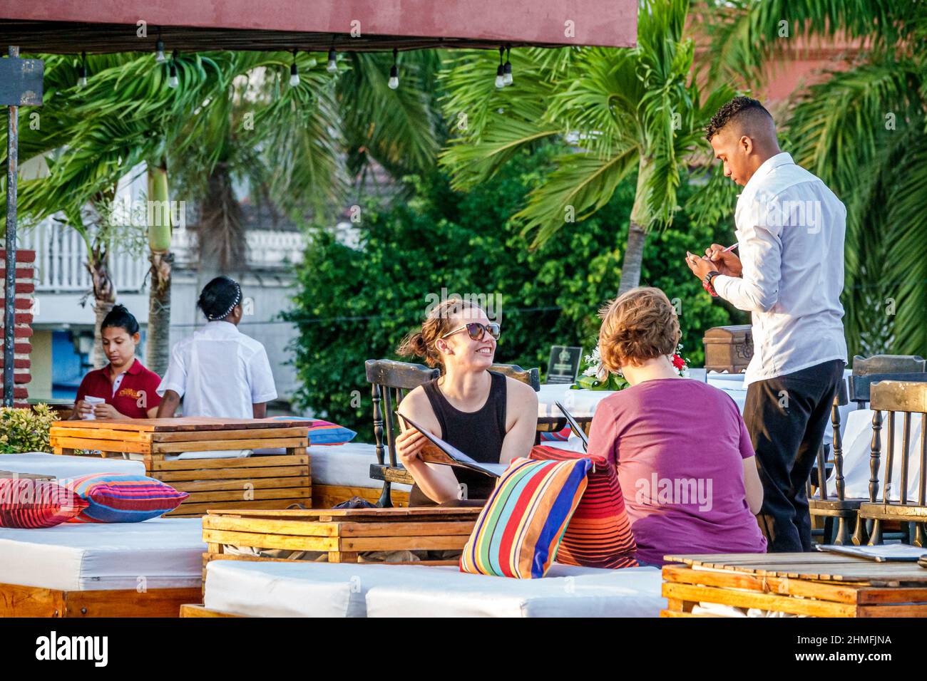 Cartagena Colombie, Getsemani, Casa de la Cerveza, restaurant en plein air à l'extérieur tables repas, hispanique Noir homme serveur employé prenant l'ordre des femmes d'écriture Banque D'Images