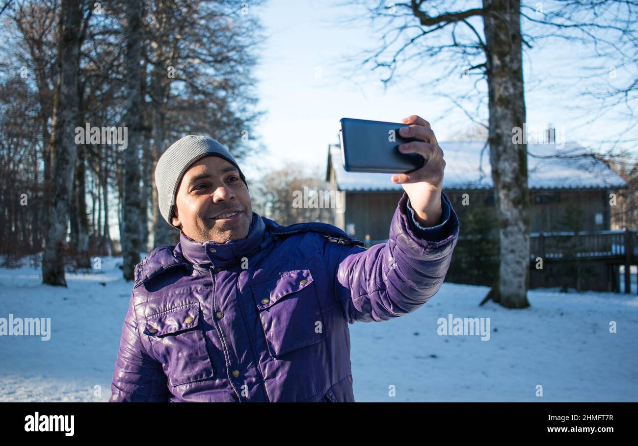 Gros plan sur un jeune homme en vacances dans les montagnes prenant selfie avec son smartphone Banque D'Images