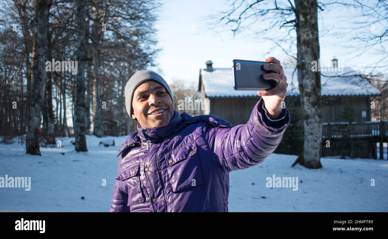 Gros plan sur un jeune homme en vacances dans les montagnes prenant selfie avec son smartphone Banque D'Images