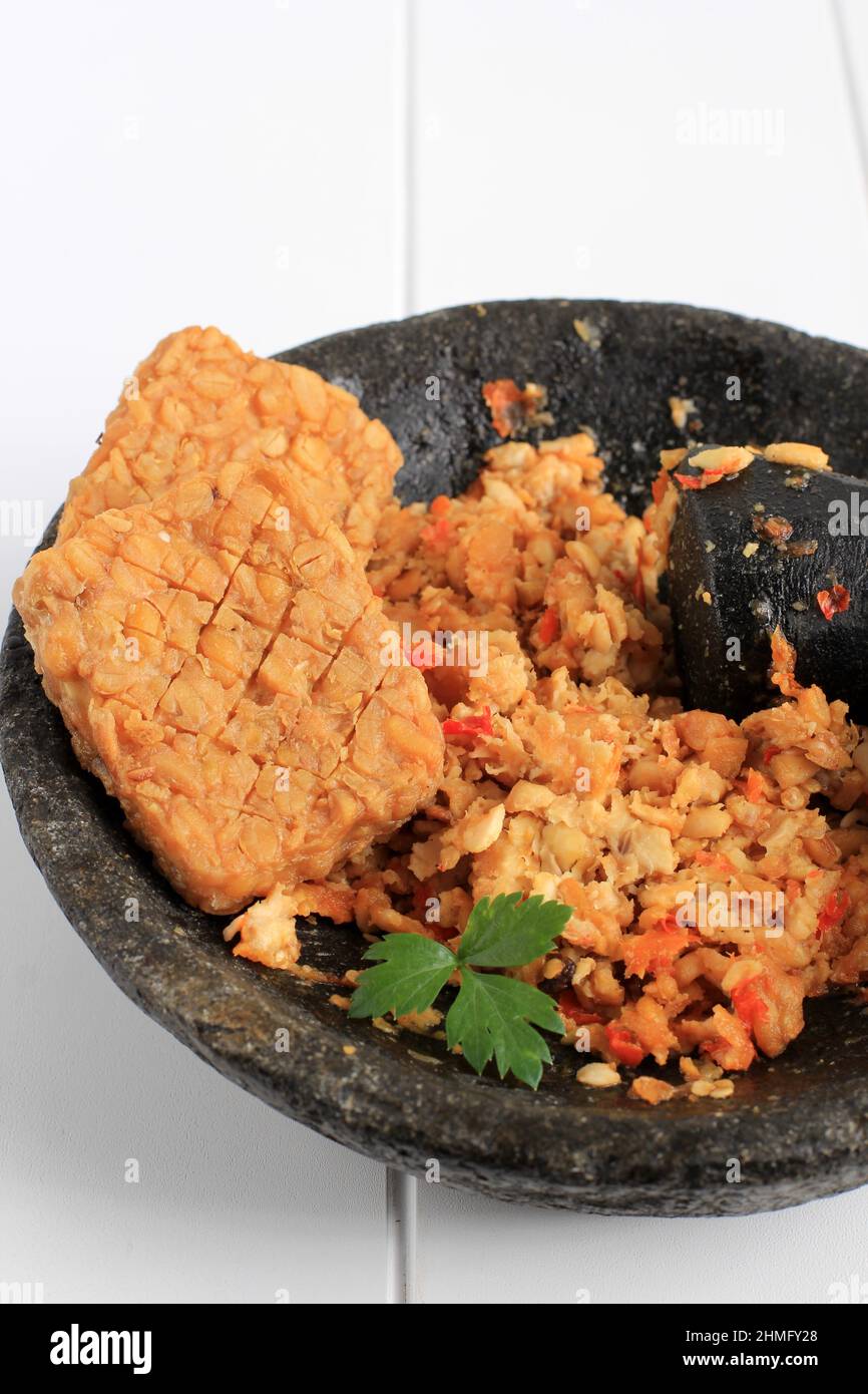 Sambel Tempeh. Tempeh avec Chili on Stone Grinder, menu populaire quotidien délicieux en Indonésie. Gros plan Banque D'Images