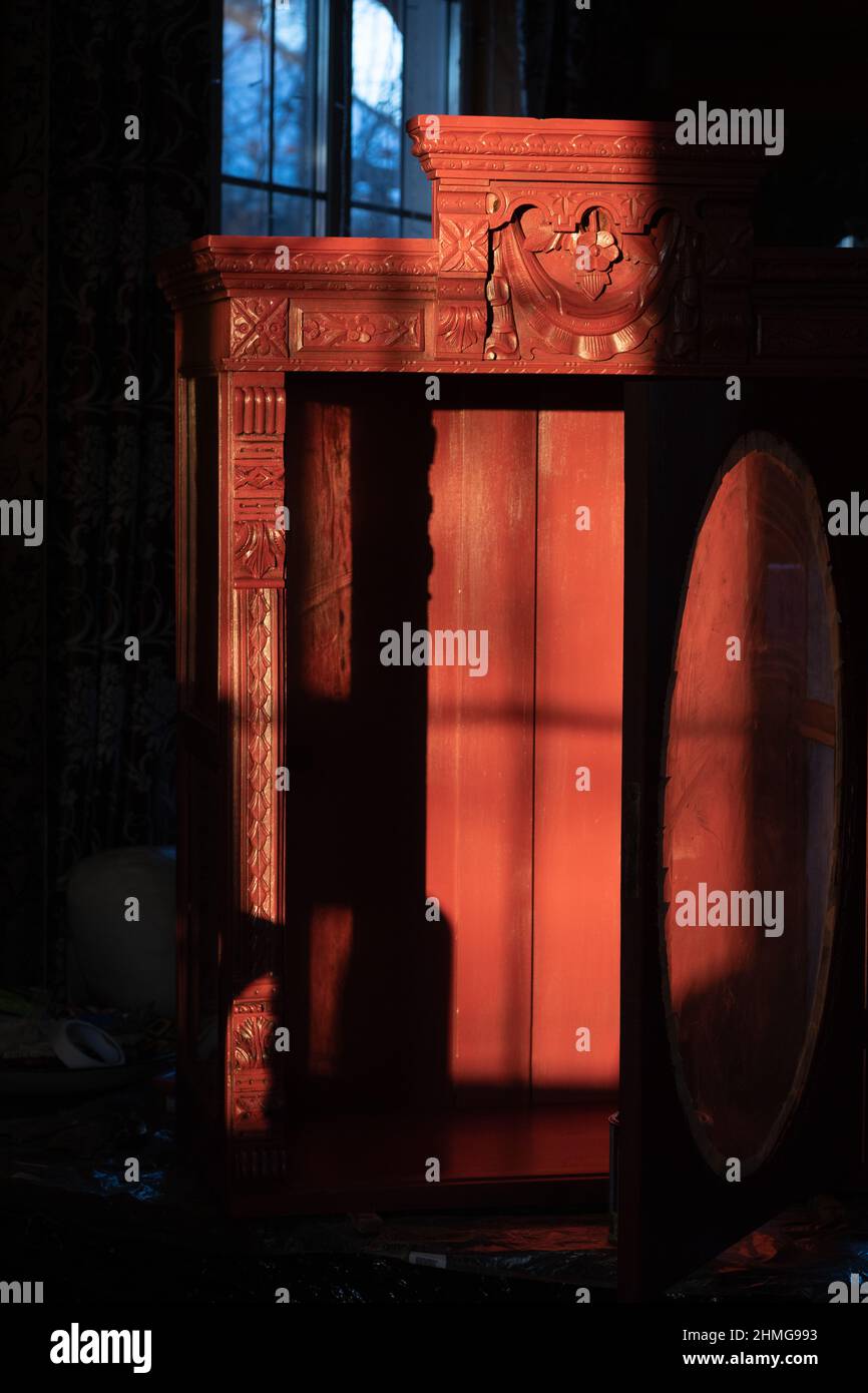 Immense placard antique en bois avec des ornements étonnants sculptés à la main avec porte ouverte dans l'obscurité avec un peu de lumière tombant dessus. Donner une nouvelle vie Banque D'Images