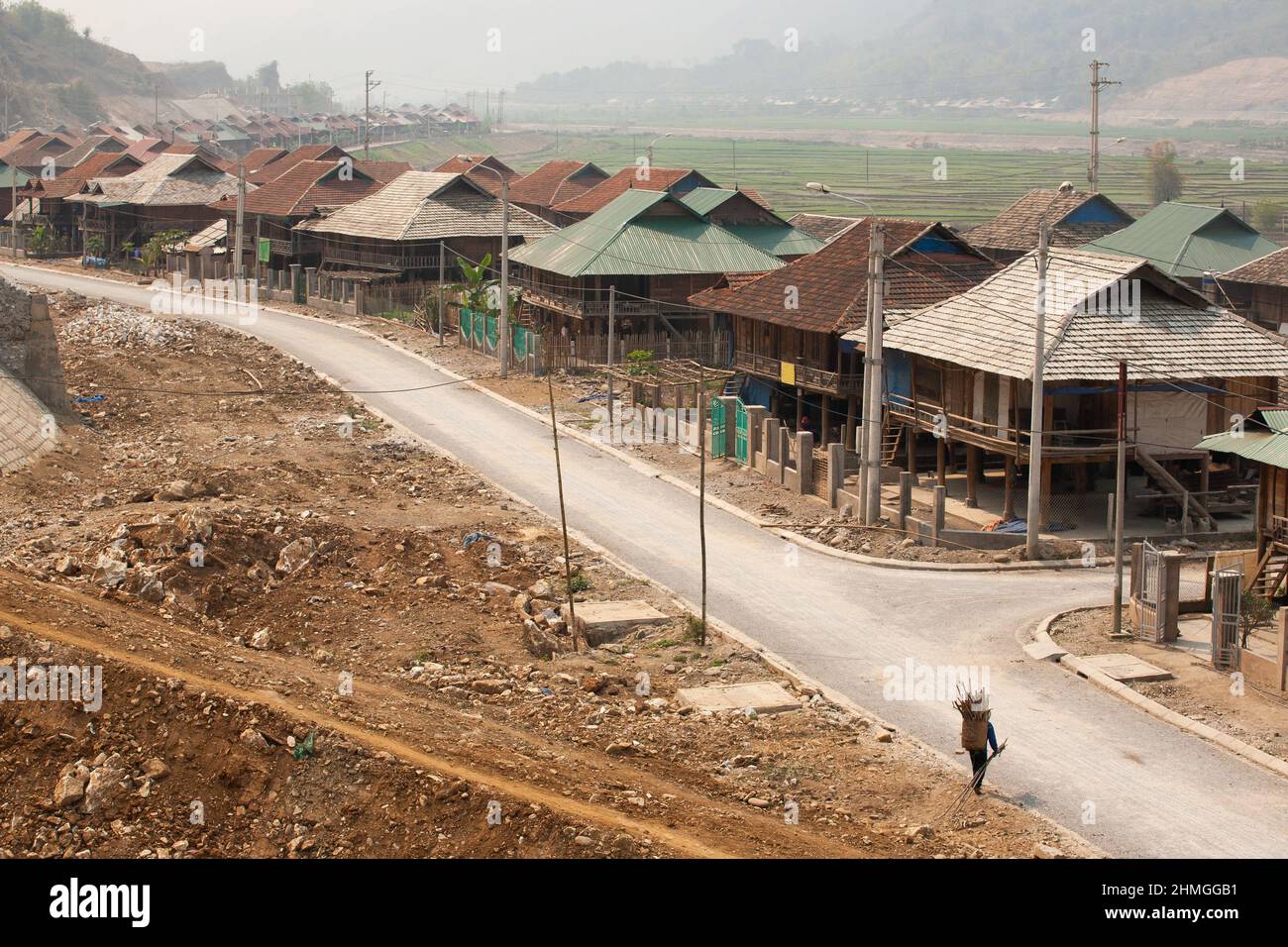 Une femme vietnamienne transportant du bois de chauffage retourne au projet hydroélectrique de Ban Chat, le barrage est construit sur la rivière Nam Mu, commune de Muong Kim, Vietnam. Banque D'Images