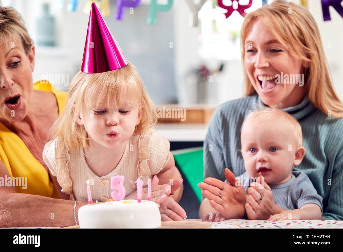 Grand-mère avec mère et petits-enfants célébrant avec la cinquième fête d'anniversaire à la maison Banque D'Images