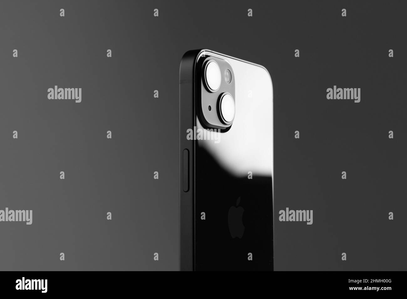 Nouveau téléphone mobile moderne iPhone 13 de couleur noire contre un mur gris Banque D'Images
