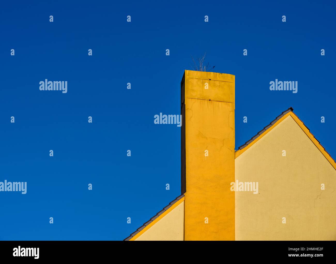 maison jaune, cheminée, ciel bleu Banque D'Images
