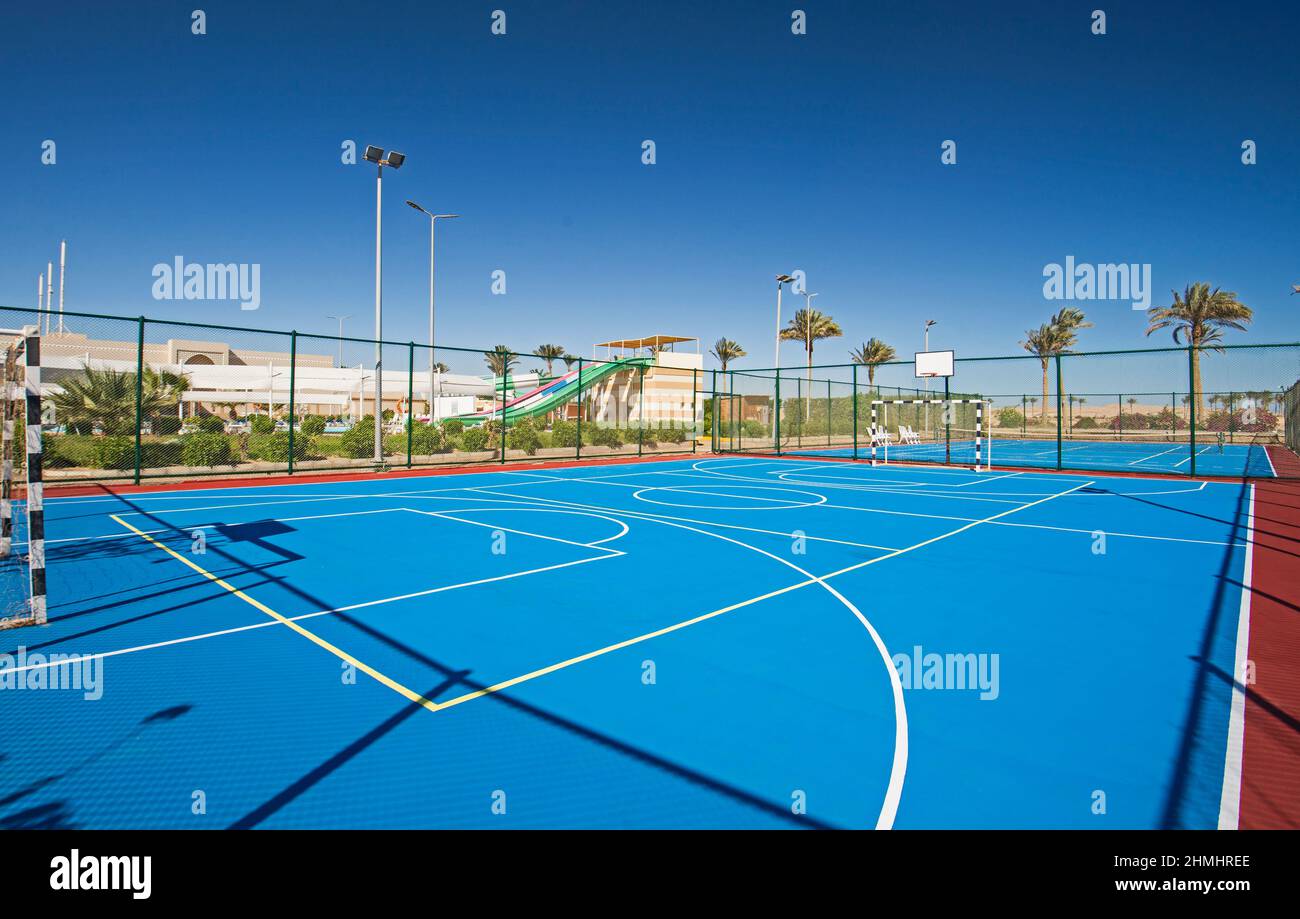 Terrain de sport polyvalent en terre battue extérieur avec surface bleue et  filets au centre de villégiature tropical de l'hôtel Photo Stock - Alamy