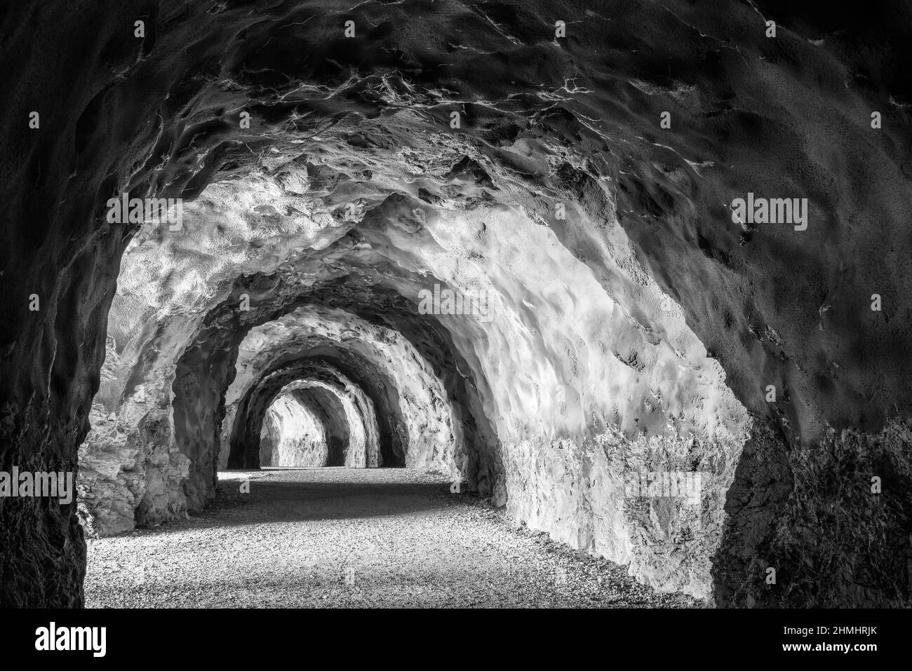 Nionunnel dans la montagne avec un sentier, s'étendant sur la distance. Perspective décroissante. Structure intéressante de la pierre. Noir et blanc. Banque D'Images Nionunnel dans la montagne avec un sentier, s'étendant sur la distance. Perspective décroissante. Structure intéressante de la pierre. Noir et blanc. Banque D'Images