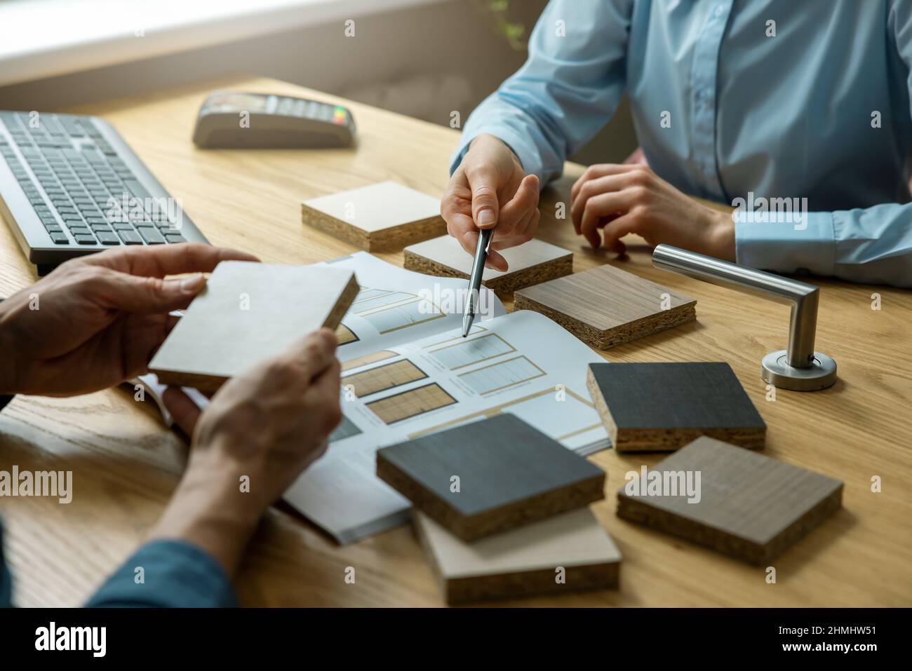 vendeur avec le client qui choisit la conception et les matériaux de la porte en magasin Banque D'Images