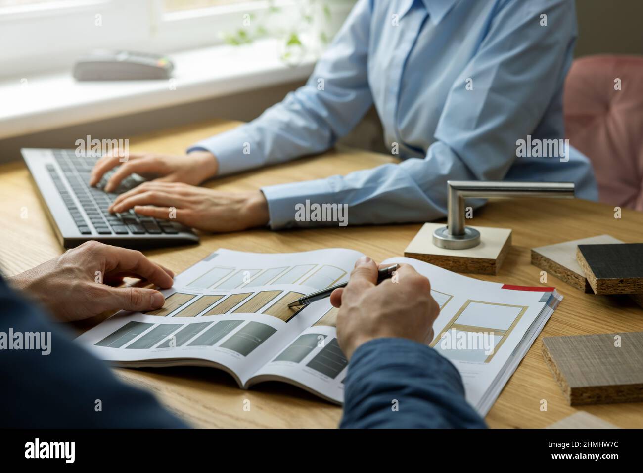 le client choisit la conception de la porte dans le catalogue de produits dans le magasin de porte Banque D'Images