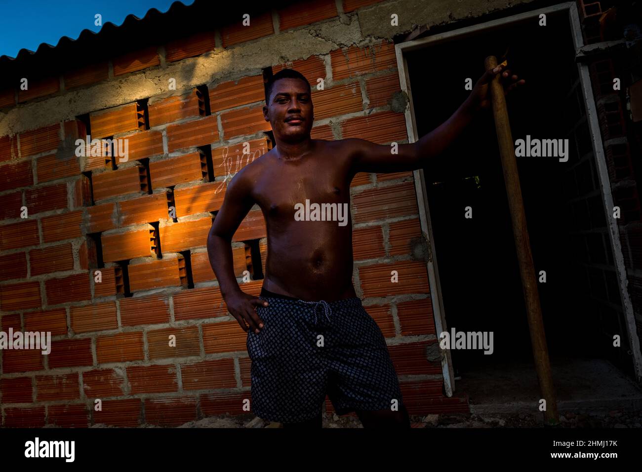 Un homme afro-colombien pose pour une photo tout en construisant sa maison à Olaya Herrera, un quartier de faible classe sociale à Cartagena, Colombie. Banque D'Images