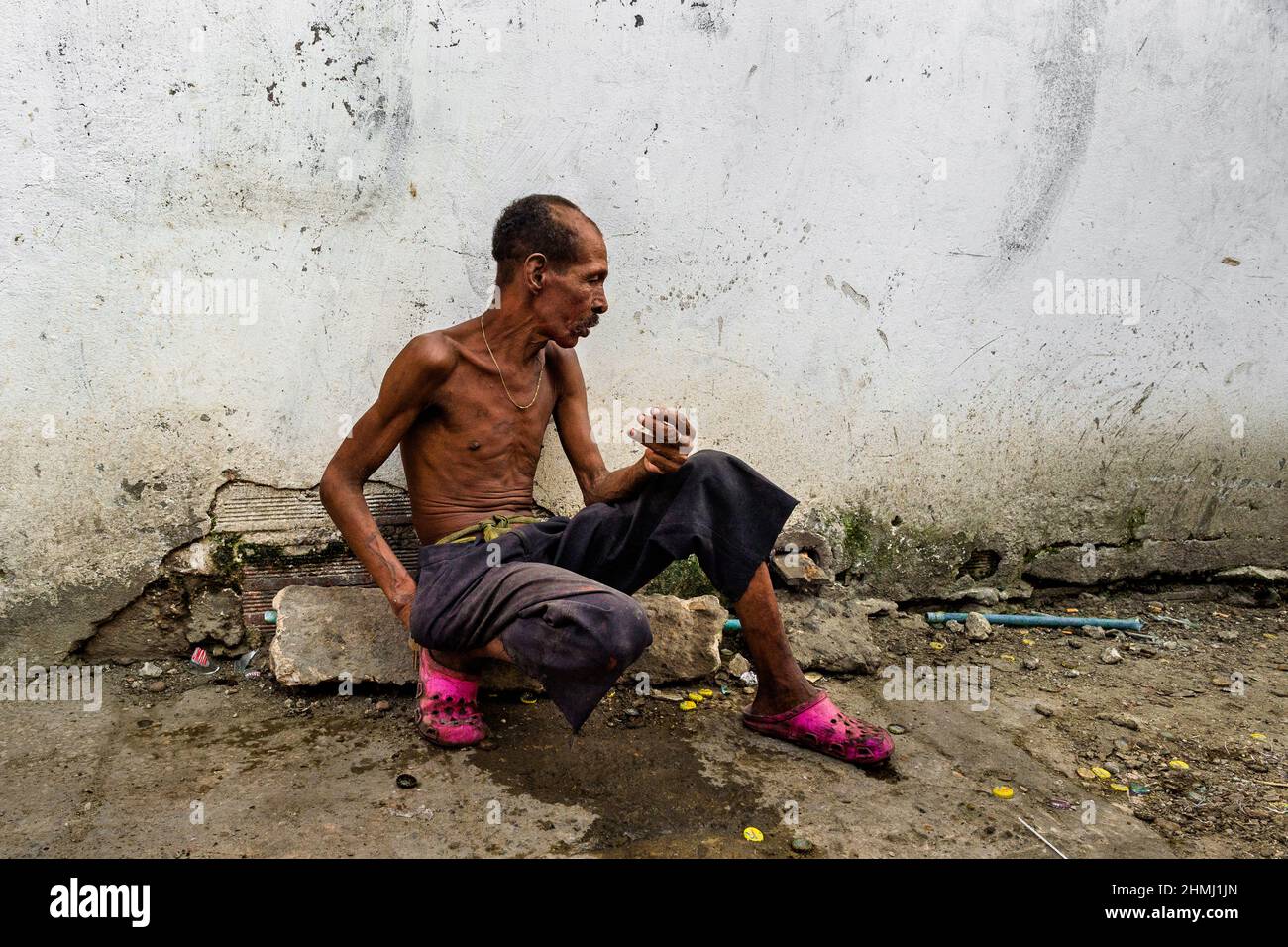 Un homme afro-colombien ayant un handicap mental parle à une personne imaginaire dans une rue à Cartagena, en Colombie. Banque D'Images