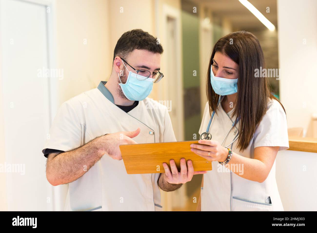 Une femme médecin et une infirmière de sexe masculin parlent et partagent de l'information à la réception du centre de santé. Banque D'Images