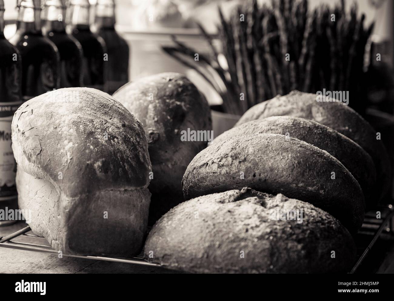 Refroidissement du pain sur un rack dans un traiteur entouré de bouteilles et d'asperges Banque D'Images