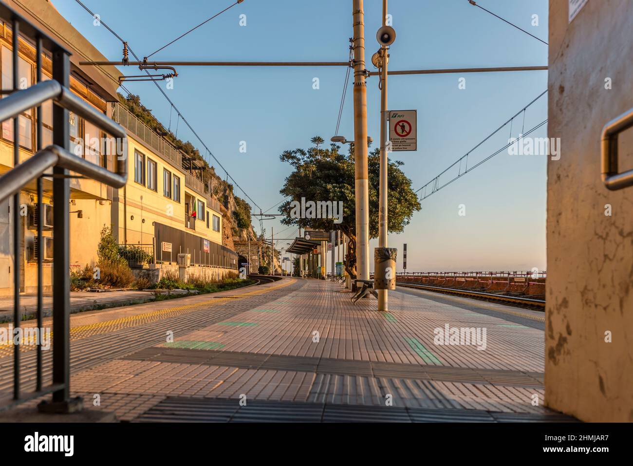 Plate-forme vide à la station de chemin de fer de bord de mer, tourné dans la lumière vive de coucher de soleil d'hiver à Manarola, Cinque Terre, Italie Banque D'Images