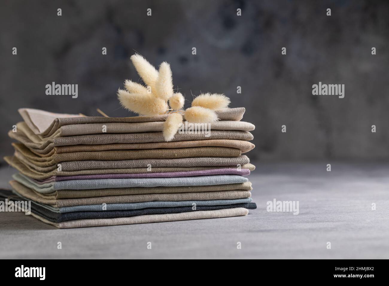 Un tas de quatre tissus en lin naturel aux couleurs ternes et pliés et  respectueux de l'environnement sur fond gris Photo Stock - Alamy