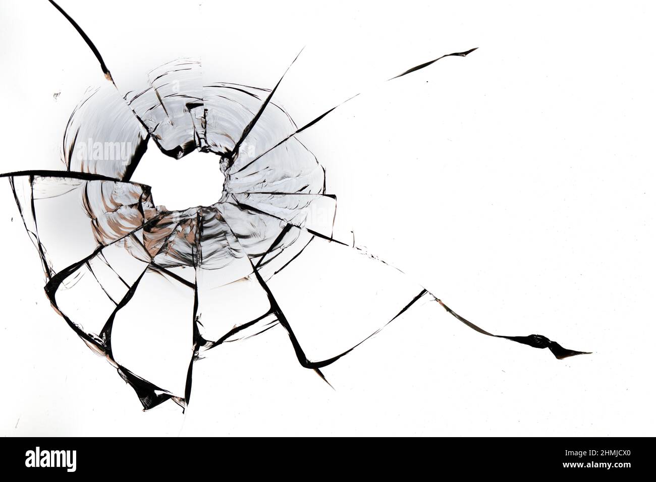 Trou de balle dans la vitre sur fond blanc. Macro. Banque D'Images