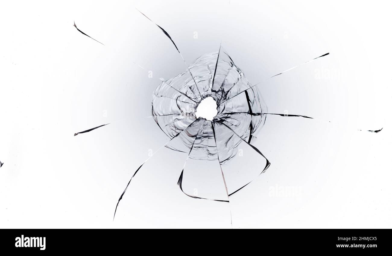 Trou de balle dans la vitre sur fond blanc. Macro. Banque D'Images