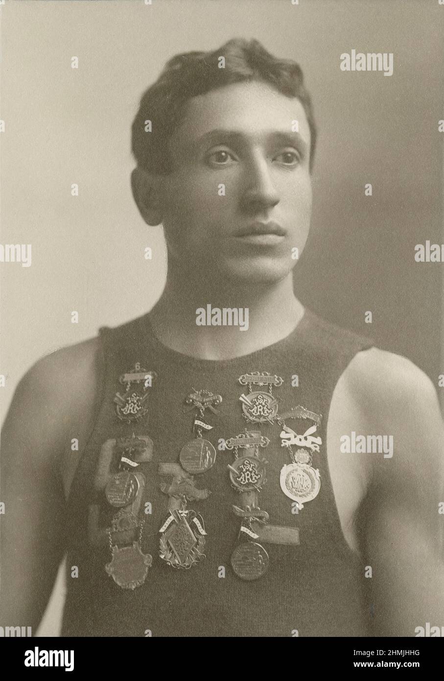 Photographie antique vers 1900 d'un jeune homme portant un haut de St. Louis avec des médailles épinglées sur sa poitrine de l'Association d'aviron amateur du Sud-Ouest. SOURCE : PHOTO DE LA CARTE DE L'ARMOIRE D'ORIGINE Banque D'Images