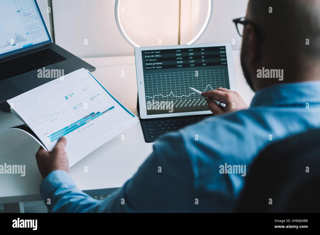 Un courtier anonyme de sexe masculin analyse des diagrammes financiers pendant le travail sur une tablette ou un ordinateur portable Banque D'Images