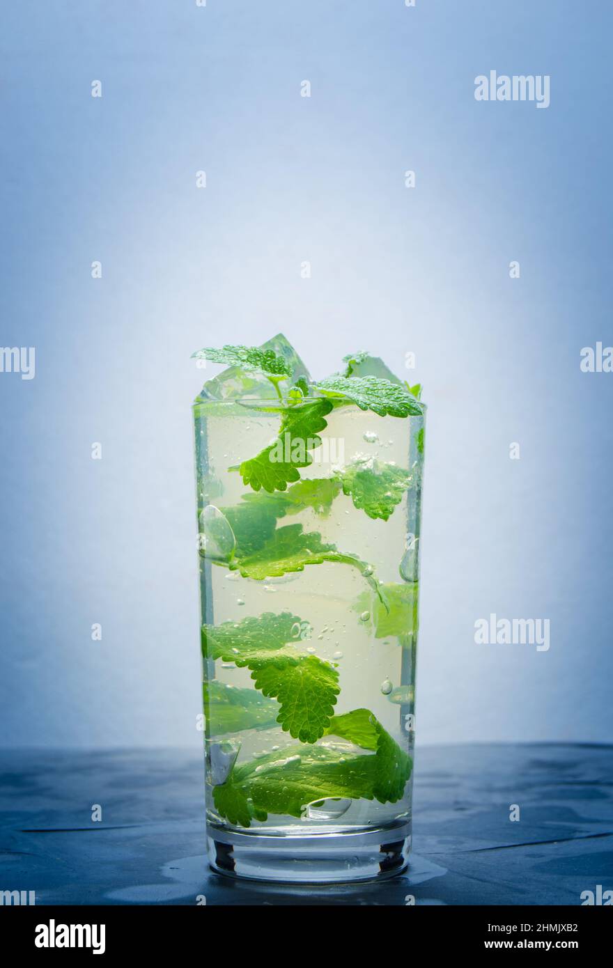 L'eau fraîche dans un verre de glace et pétales menthe.Soft drink, avec le vignetage. Banque D'Images