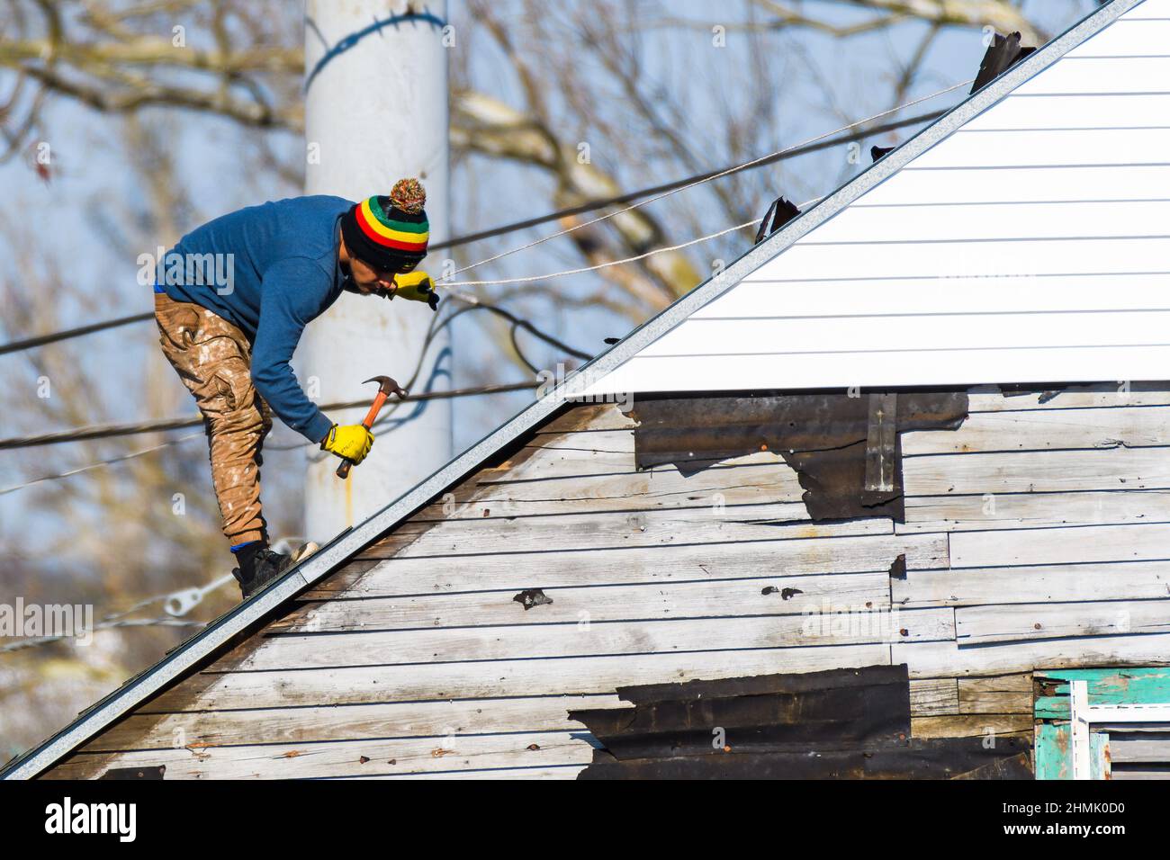 LA NOUVELLE-ORLÉANS, LA, États-Unis - 9 FÉVRIER 2022 : ouvrier effectuant des réparations de toit avec un marteau en main Banque D'Images