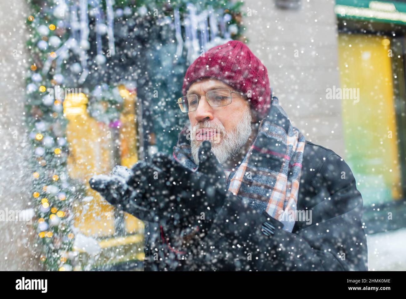 heureux homme mature en hiver marché de noël en plein air avec paysage urbain en arrière-plan Banque D'Images
