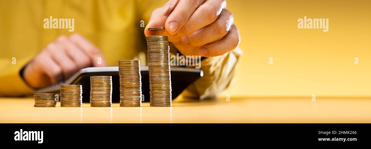 Homme D'Affaires Calculant La Facture Avec Des Pièces Empilées Organisées Au Bureau Banque D'Images