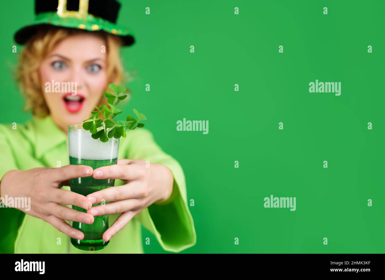 Saint Patrick. Femme de beauté en chapeau de leprechaun avec bière verte. Tradition irlandaise. Mise au point sélective. Banque D'Images