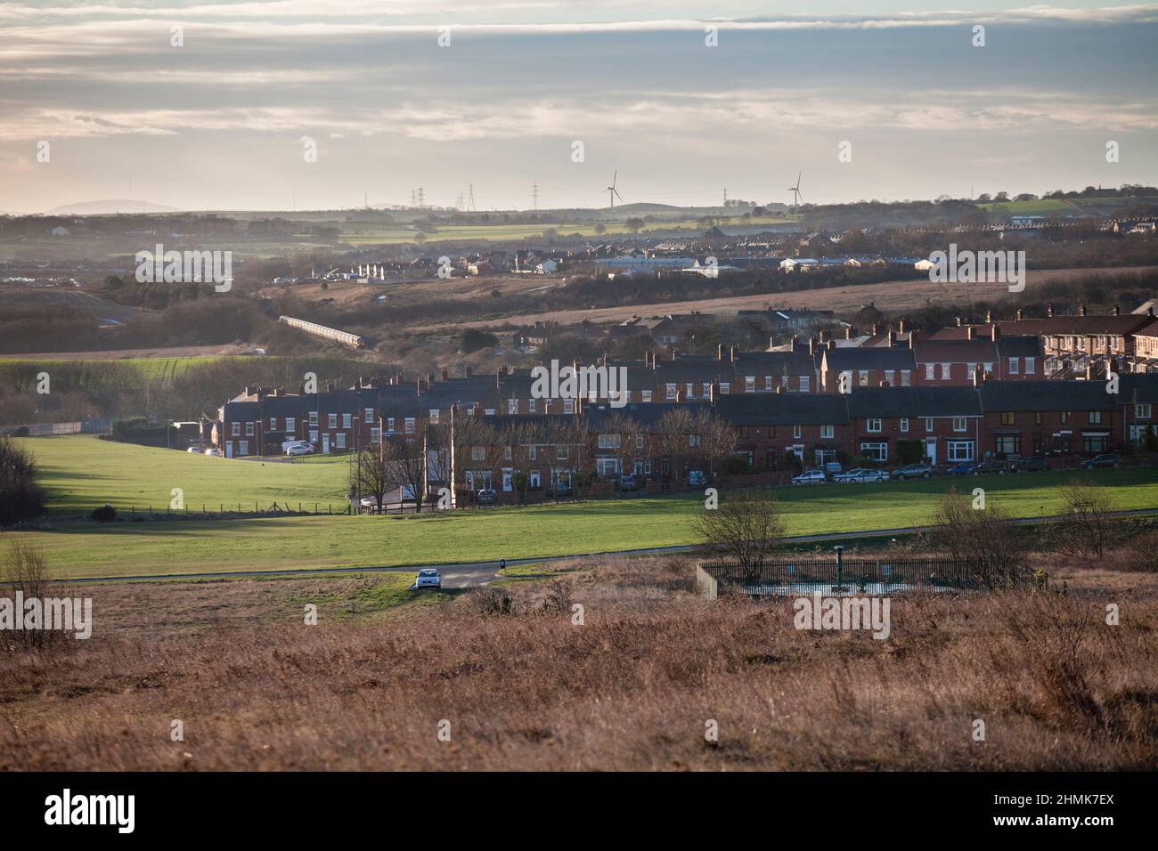 Comté de la mine de charbon Easington Durham rangées de maisons en terrasse avec un train de biomasse passant en arrière-plan et tête de fosse à capuchon en premier plan Banque D'Images