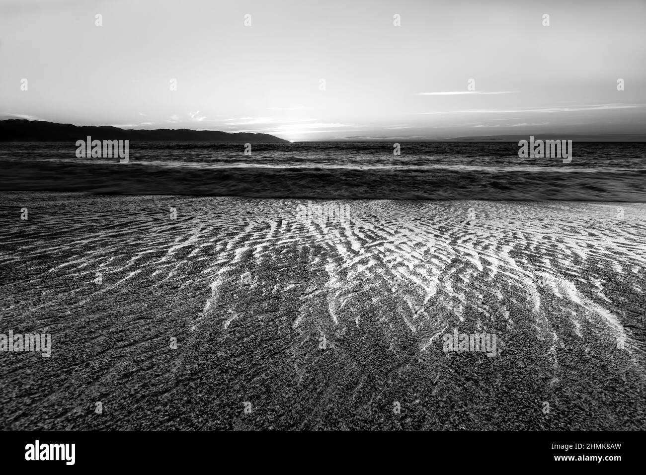 Image haute résolution Paysage océanique avec Une zone d'avant-plan ondulée en sable détaillée au format d'image noir et blanc Banque D'Images