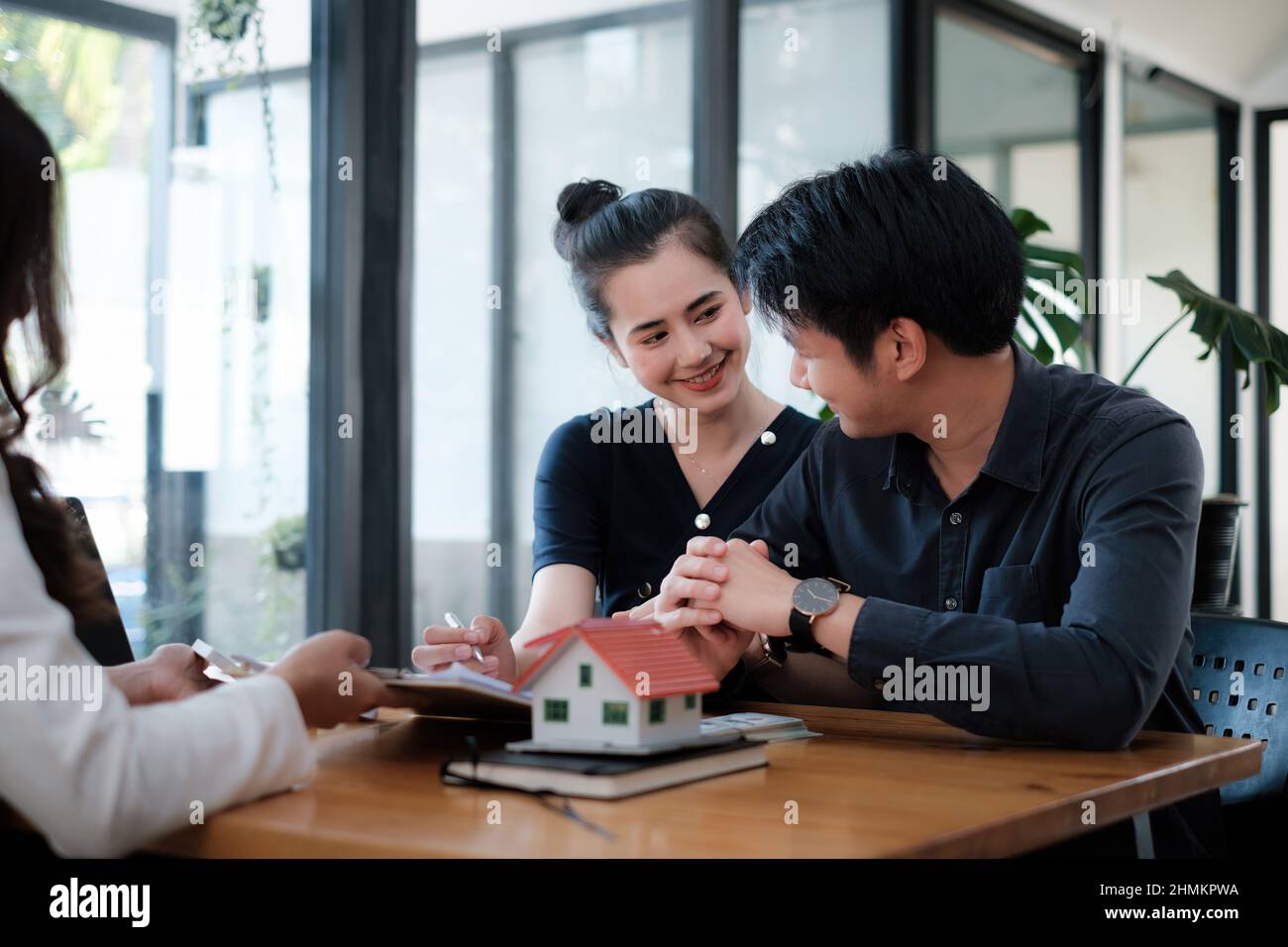 Une femme d'affaires et un jeune couple signent un accord pour acheter une maison. Directeur de banque et concept immobilier. Banque D'Images