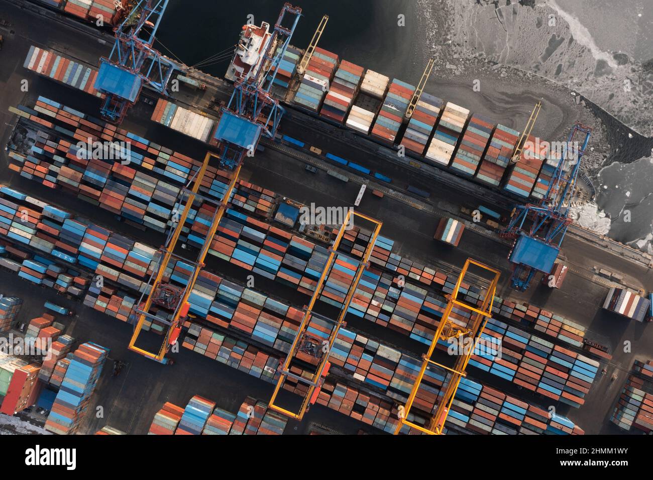 Vladivostok, Russie - 26 janvier 2022 : Vue de dessus du terminal des conteneurs du port maritime.En hiver, un bateau à conteneurs est en train de charger à l'embarcadère. Banque D'Images