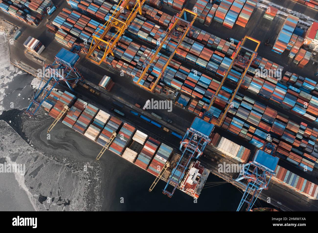 Vladivostok, Russie - 26 janvier 2022 : Vue de dessus du terminal des conteneurs du port maritime.En hiver, un bateau à conteneurs est en train de charger à l'embarcadère. Banque D'Images