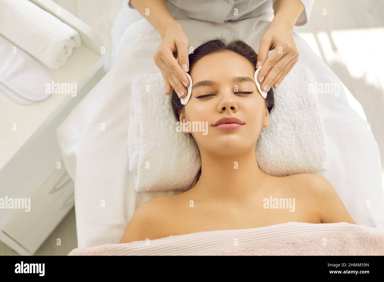 Une femme heureuse se fait enlever son maquillage avant de se faire soigner au centre de beauté Banque D'Images