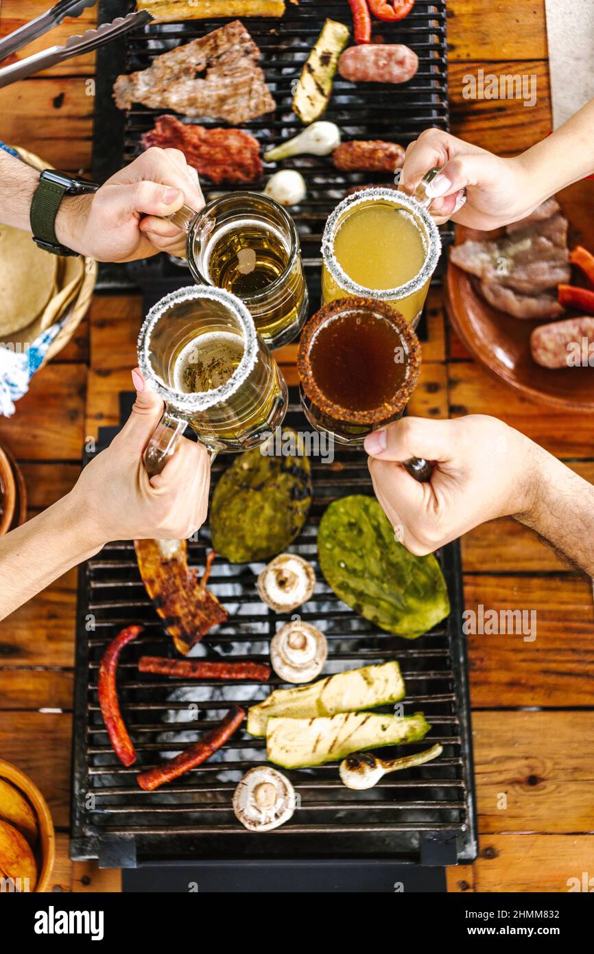 Groupe d'amis latins mangeant des Tacos mexicains et de la nourriture traditionnelle, des collations et des gens mains sur la table, vue de dessus. Cuisine mexicaine Amérique latine Banque D'Images