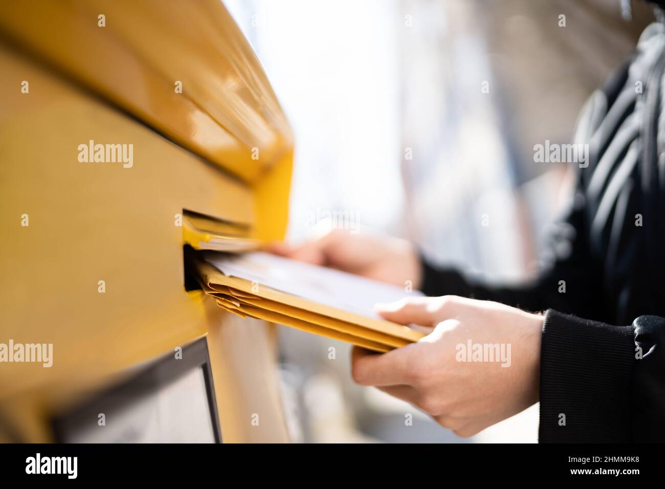 Lettre dans l'enveloppe ou document dans la boîte aux lettres. Homme main envoyant le courrier Banque D'Images