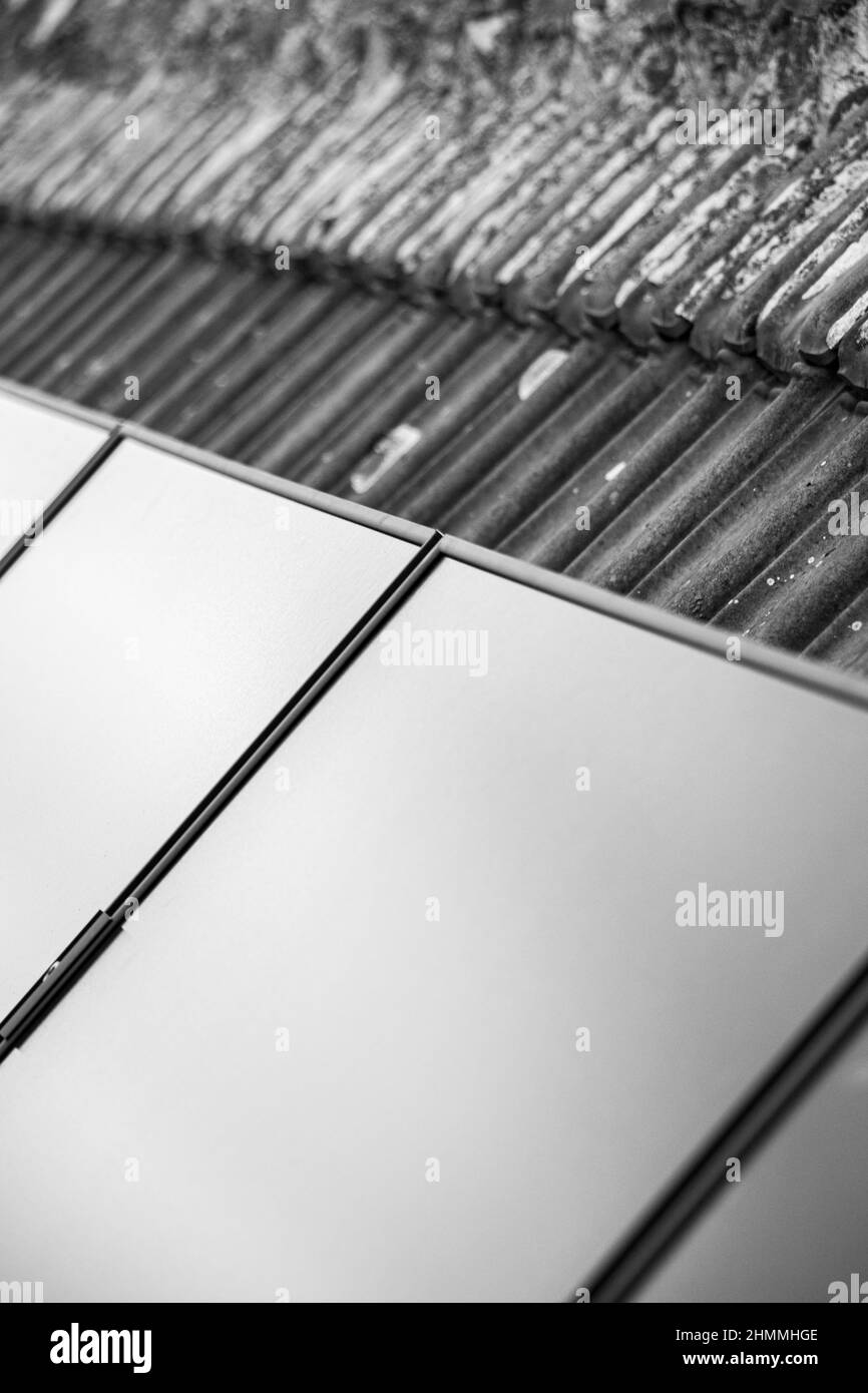 Gros plan d'une installation d'un ensemble de panneaux solaires, installés sur le dessus d'une maison avec tuiles de toit. Banque D'Images