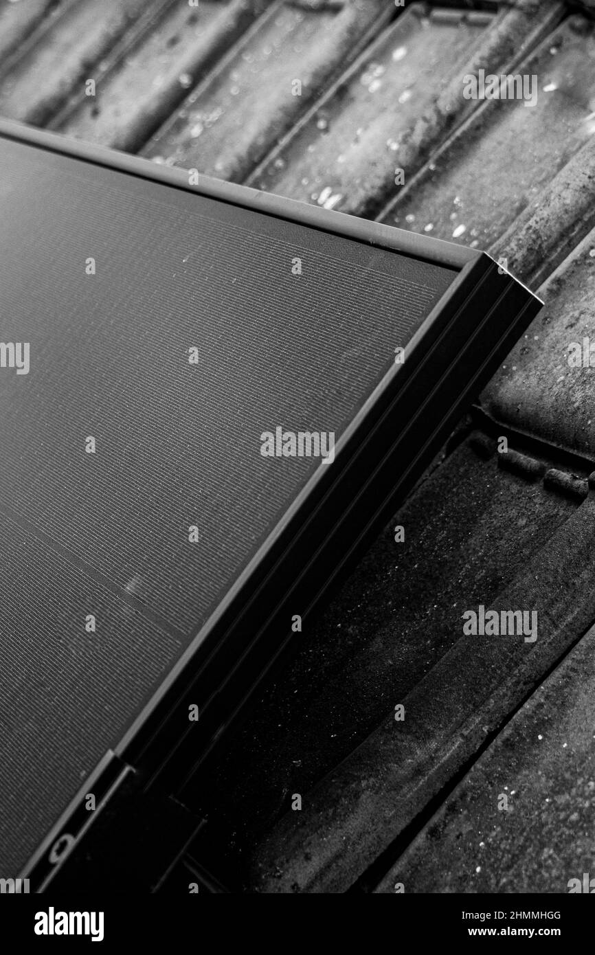 Gros plan d'une installation d'un ensemble de panneaux solaires, installés sur le dessus d'une maison avec tuiles de toit. Banque D'Images