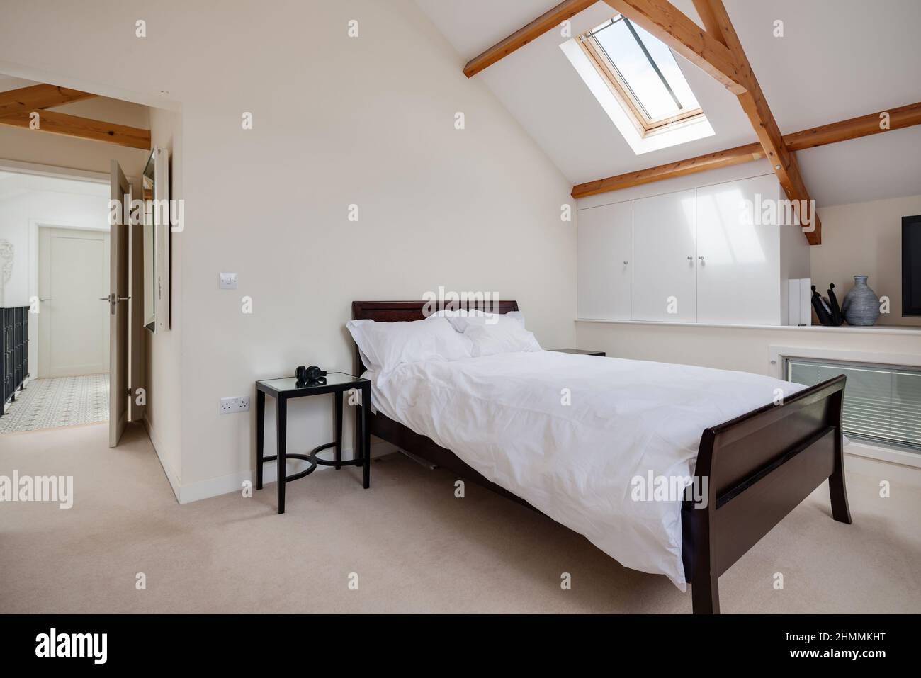 Newport, Essex - juillet 10 2018: Chambre à coucher avec lit, table et plafond voûté avec poutres apparentes. Banque D'Images